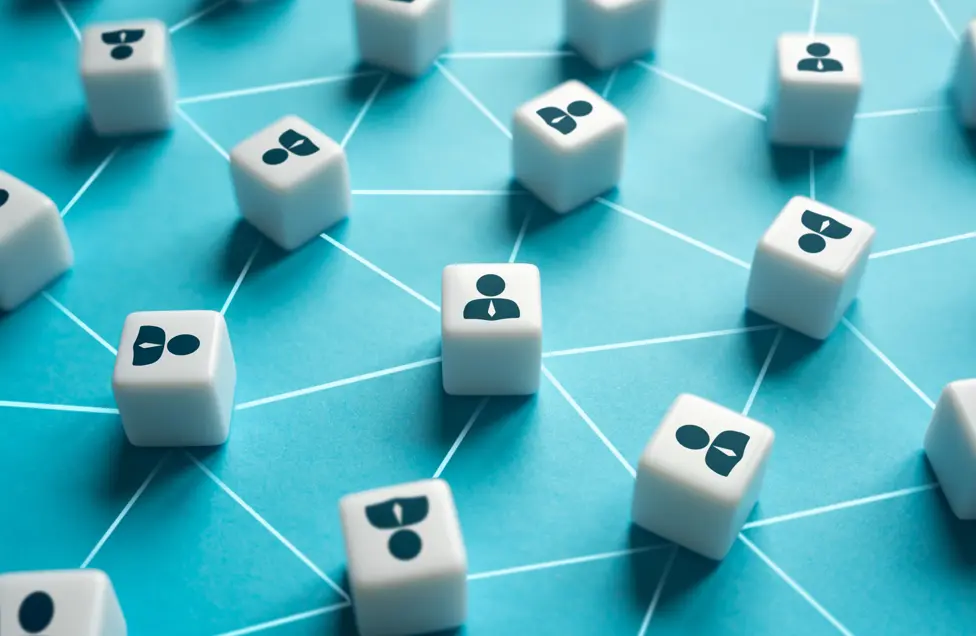 Cubos com ícones de pessoas conectados por linhas sobre fundo azul, simbolizando redes de reputação e relações com stakeholders.