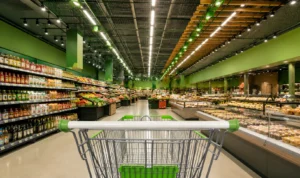 Interior de supermercado moderno com corredores amplos e iluminação em destaque, representando o setor varejista