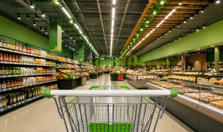 Interior de supermercado moderno com corredores amplos e iluminação em destaque, representando o setor varejista